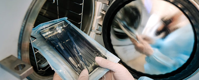 Pessoa usando uma autoclave para demosntrar os tipos de esterilização.